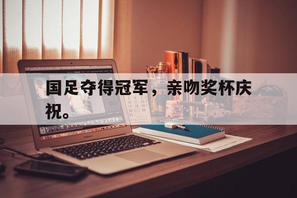 国足夺得冠军，亲吻奖杯庆祝。